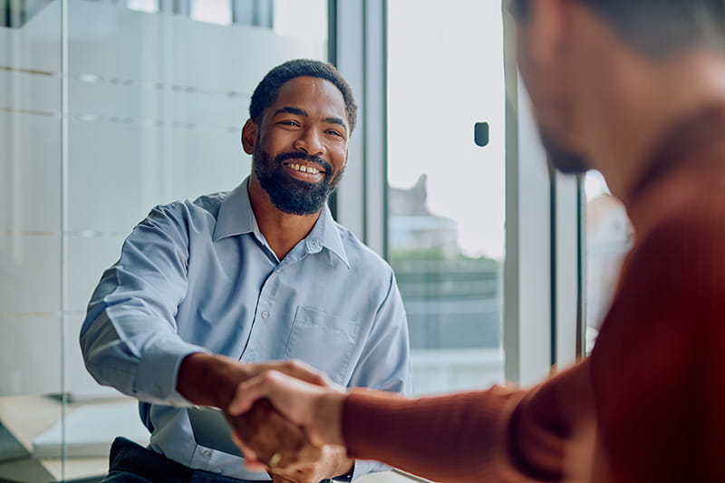 Smiling person shaking hands with someone else