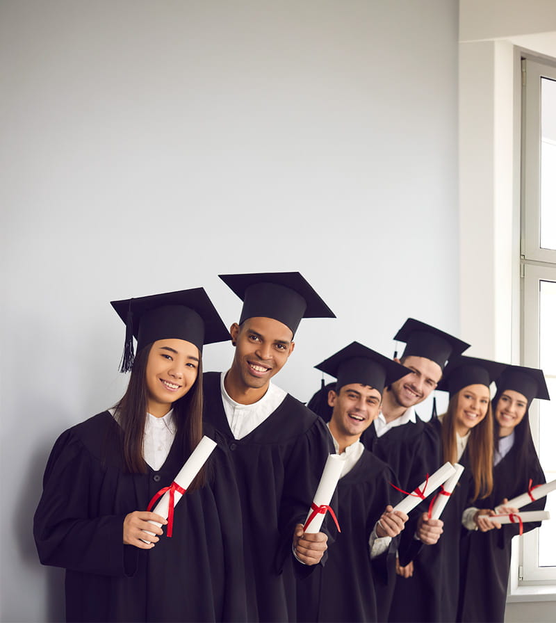 Group of students in the cap and gowns with diplomas in their hands