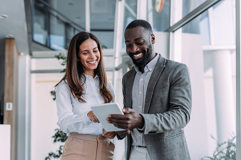 2 employees talking about information on a tablet